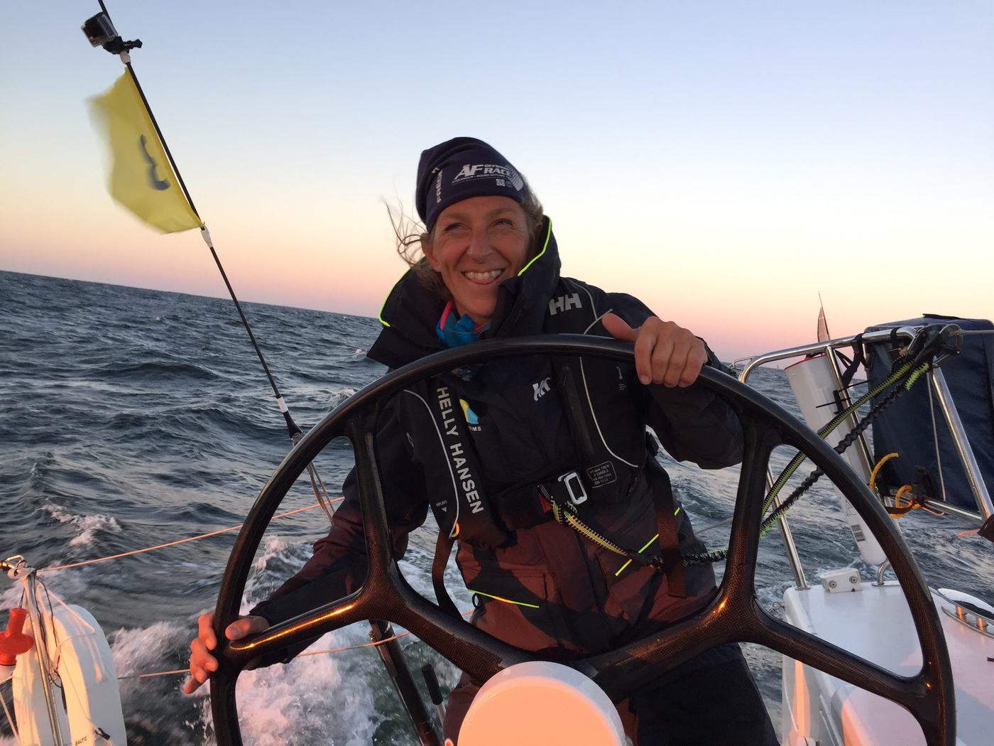 Pia L'Obry at the helm of a sailing boat at sunset
